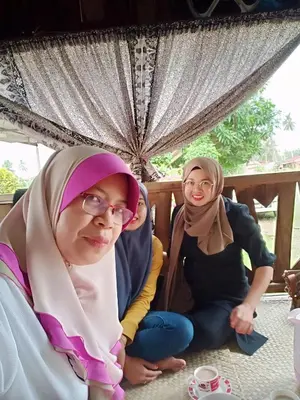 a group of three women sitting on the floor at Homestay Damai Sri Kota in Kepala Batas