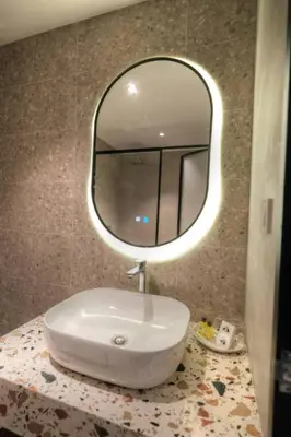 a bathroom with a sink and a mirror on a counter at The Jerai Hotel Sungai Petani in Sungai Petani