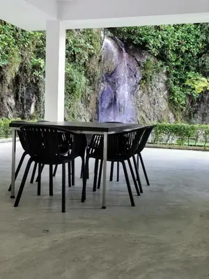 a black table with two chairs in front of a waterfall at Mr.J Homestay in Taiping
