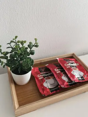 a wooden tray with a potted plant and a packet of chips at Taiping Centre Point Suite 9 by BWC in Taiping