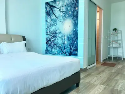 a bedroom with a bed and a painting on the wall at PM Octagon Ipoh Duplex Suite (4-12paxs) in Ipoh