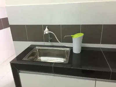 a kitchen counter with a sink and a faucet at Kampar Private Roomstay W in Kampar