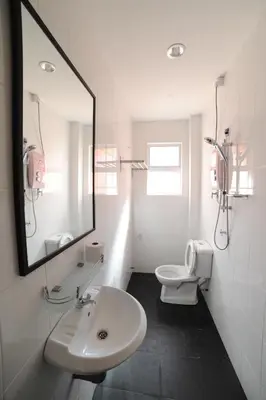 a bathroom with a sink and a toilet and a mirror at The Osborne Apartments in Ipoh