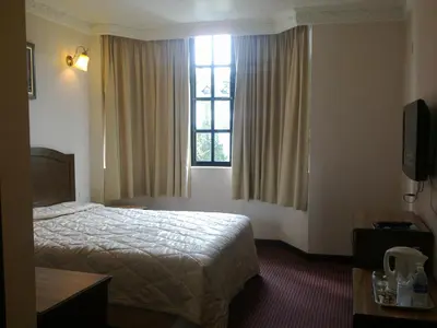 a hotel room with a bed and a window at Hotel Remix in Cameron Highlands