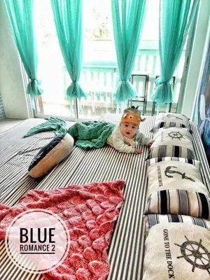a baby laying on a bed in a bedroom at Blue Romance Mermaid Cameron Stay 9 pax Next to Night Market in Cameron Highlands