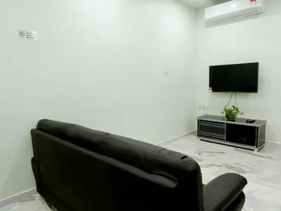 a black couch in a living room with a television at Taiping Cozy Homestay II in Taiping