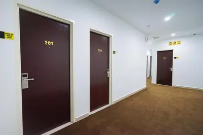 a hallway with three doors with the number on them at Grand FC Hotel in George Town