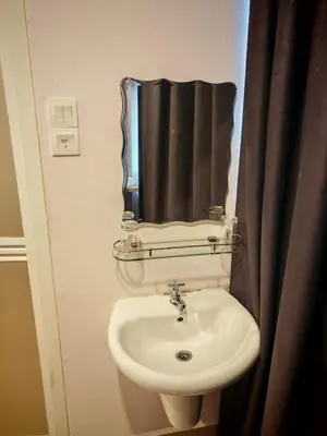 a bathroom with a sink and a mirror at Grand FC Hotel in George Town
