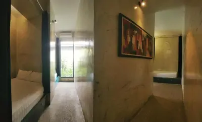 a room with a bed and a picture on the wall at Beds In Garden Hostel in Ipoh