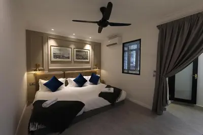 a bedroom with a large bed with blue pillows at Manhattan Residence in George Town