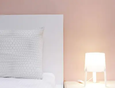 a bed with a white pillow and a lamp at TheDaun Homestay Seri Iskandar, Perak in Seri Iskandar