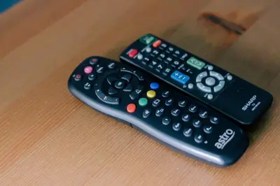 two remote controls sitting on top of a table at TheDaun Homestay Seri Iskandar, Perak in Seri Iskandar