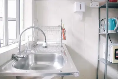 a kitchen sink with a faucet next to a window at TheDaun Homestay Seri Iskandar, Perak in Seri Iskandar