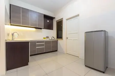 a kitchen with a sink and a refrigerator at Kinta Riverfront Hotel & Suites in Ipoh
