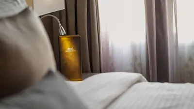 a book sitting on a bed next to a window at Bahari Parade Hotel Managed by The Ascott Limited in George Town