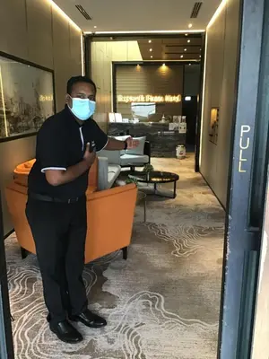 a man wearing a face mask in an office at Ropewalk Piazza Hotel Managed by The Ascott Limited in George Town