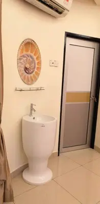 a bathroom with a toilet and a sink and a mirror at Rocky Farm in Ipoh