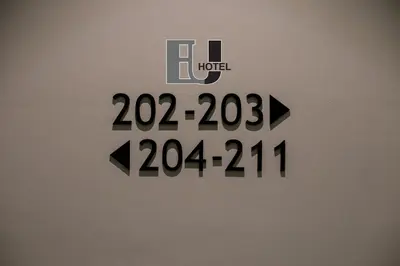 a clock on a wall with the words hudu with arrows at Eureka Hotel Penang in Bayan Lepas