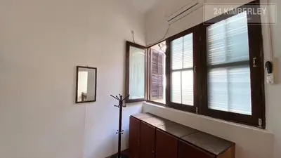 a room with two windows and a wooden dresser at 24 Kimberley in George Town