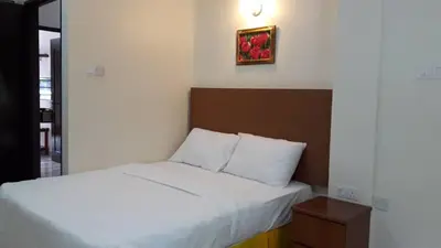 a bedroom with a bed and a picture on the wall at TULIP HOTEL & APARTMENT in Cameron Highlands