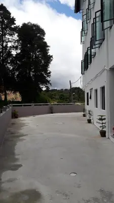 an empty parking lot in front of a building at TULIP HOTEL & APARTMENT in Cameron Highlands