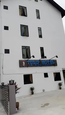 a white building with a sign on it at TULIP HOTEL & APARTMENT in Cameron Highlands