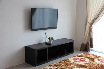 a black entertainment center with a flat screen tv on a wall at Casa D'One Homestay D Pasar Malam in Cameron Highlands