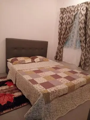 a bed with a quilt on it in a bedroom at Casa D'One Homestay D Pasar Malam in Cameron Highlands
