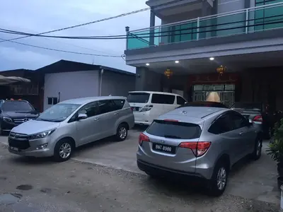 two cars parked in a parking lot in front of a building at CK Homestay K.Sepetang in Taiping