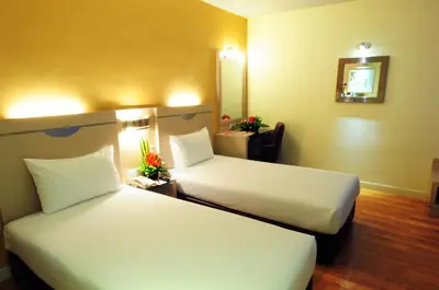 a hotel room with two beds and a mirror at Hotel Sentral Georgetown @ City Centre in George Town