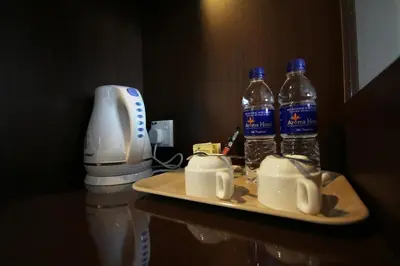 two bottles of water on a tray next to a coffee maker at Aroma Hotel in Butterworth