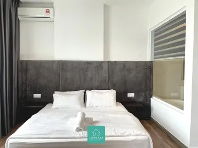 a bedroom with a bed and a bath tub at JOMSTAY Octagon Palm Suites Ipoh in Ipoh