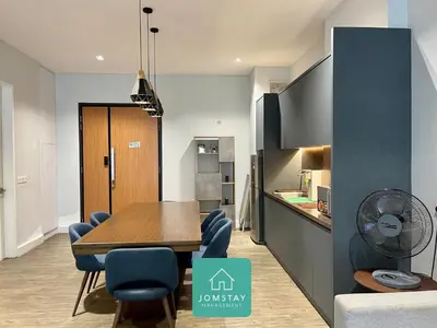 a dining room with a table and blue chairs at JOMSTAY Octagon Palm Suites Ipoh in Ipoh