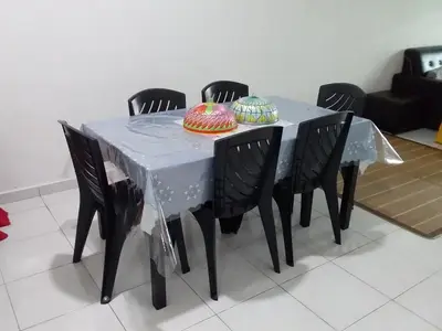 a table with four chairs and a table with two cakes on it at Wany Homestay & Guest House in Sungai Petani