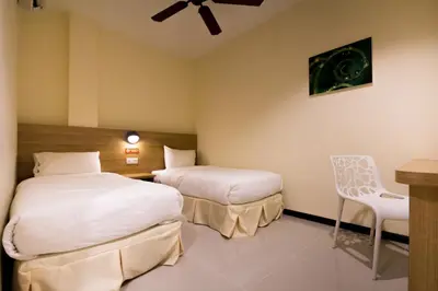 a hotel room with two beds and a chair at 118 Hotel,Dato Keramat - Self Check In in George Town