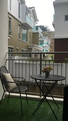 a table and a chair on a balcony at Aalina's Comfort Home - Muslim Homestay in Cameron Highlands