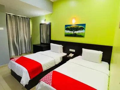 two beds in a room with green walls at Ct Hotel in Sitiawan