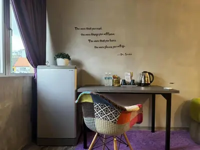 a table with a refrigerator and a table with a chair at Ipoh Zing Vale - Family & Couple Suite in Ipoh
