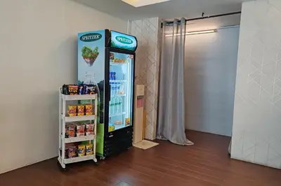 a cocacola refrigerator next to a shelf in a room at Hotel 18 Ipoh Aeon Mall in Ipoh