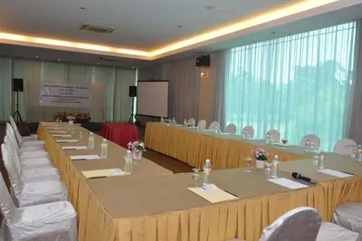 a large meeting room with long tables and white chairs at RPGC Garden Hotel in Ipoh