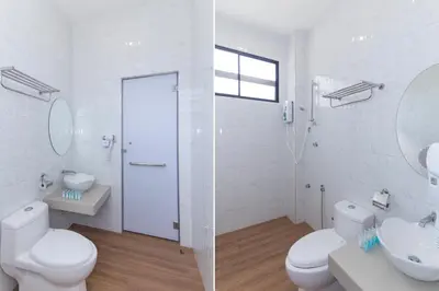 a white bathroom with two toilets and a sink at Rock Mountain in Raub