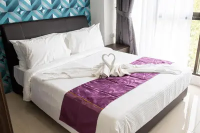 a white bed with a purple and white blanket at Rock Mountain in Raub