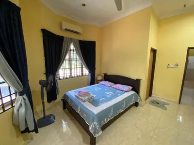 a bedroom with a bed and a window at Idaman homestay in Bukit Mertajam