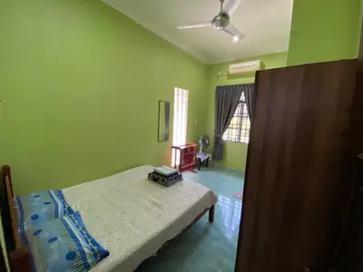 a bedroom with a bed in a room with green walls at Idaman homestay in Bukit Mertajam