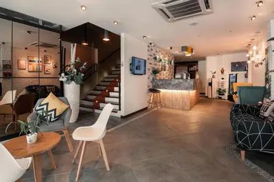 a living room with a table and chairs and a staircase at Apple Hotel Times Square in George Town