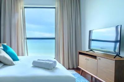 a bedroom with a bed and a flat screen tv at Tanjung Point Residences in George Town