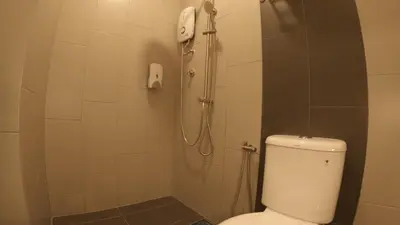 a bathroom with a shower with a toilet and a phone at U Design Hotel Kuala Lipis in Kuala Lipis