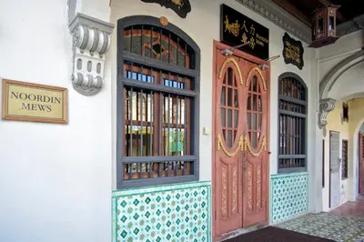 a building with two doors and a sign on it at Noordin Mews in George Town