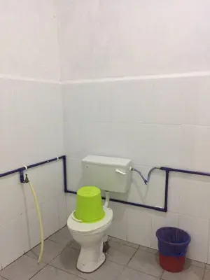 a toilet with a green seat in a bathroom at Bunga Raya Guest House BALING in Baling