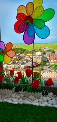 a colorful flower arrangement on a table with flowers at WindMill SunRise PaddyView Homestay in Sekincan